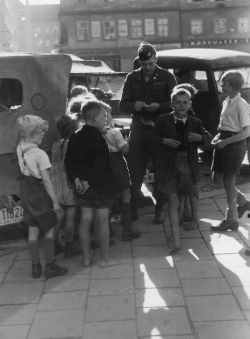 Foto: Archiv der Stadt Linz Ein amerikanischer Militärgeistlicher verteilt Süßigkeiten an Kinder